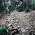 man riding mountain bike ramping on forest
