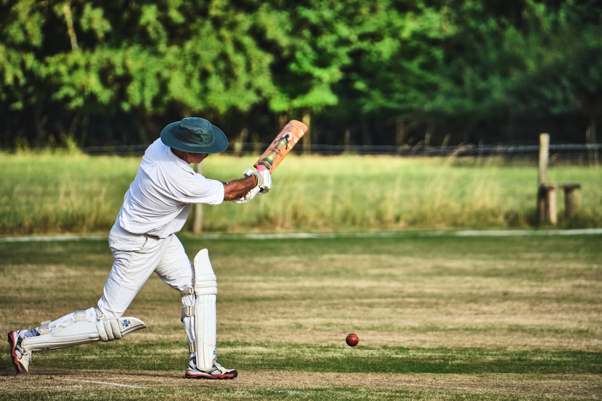 man in white pants and blue baseball mitt holding baseball bat during daytime, cricket Pioltello