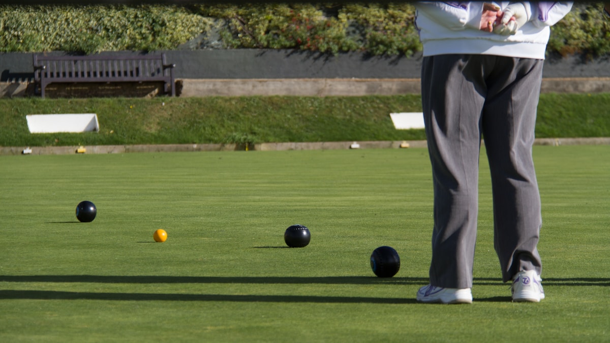 man in gray pants standing on green grass field during daytime campi di bocce a Milano