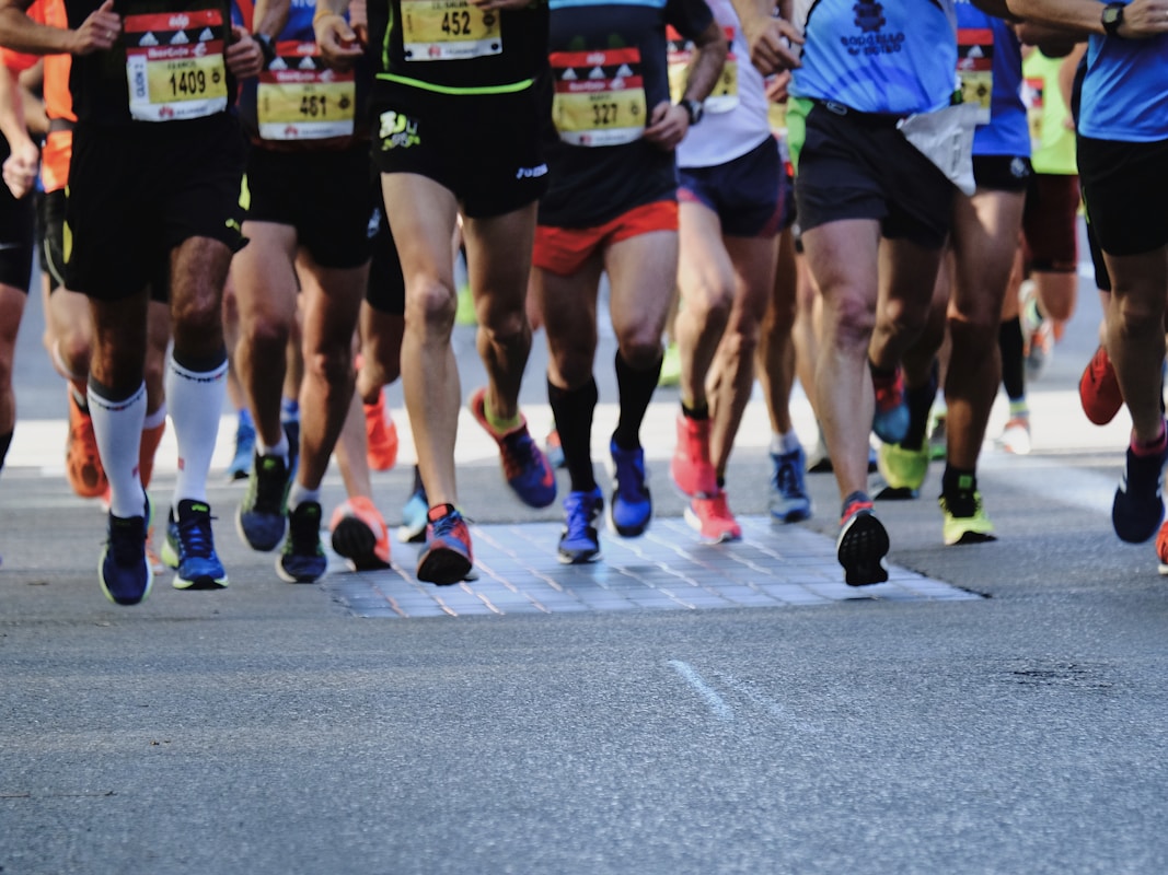 people running on gray asphalt road during daytime scegliere scarpe running