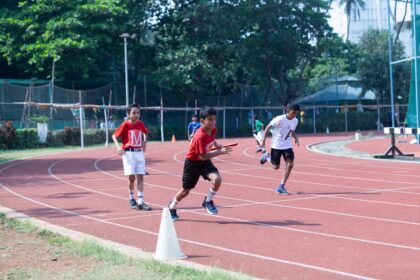 a group of young men running around a track Sport per bambini a Milano: corsi consigliati