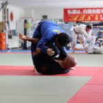 two men dueling inside room corsi di sumo a Milano