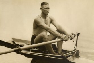 a man rowing a boat on a body of water storia della canoa a Milano
