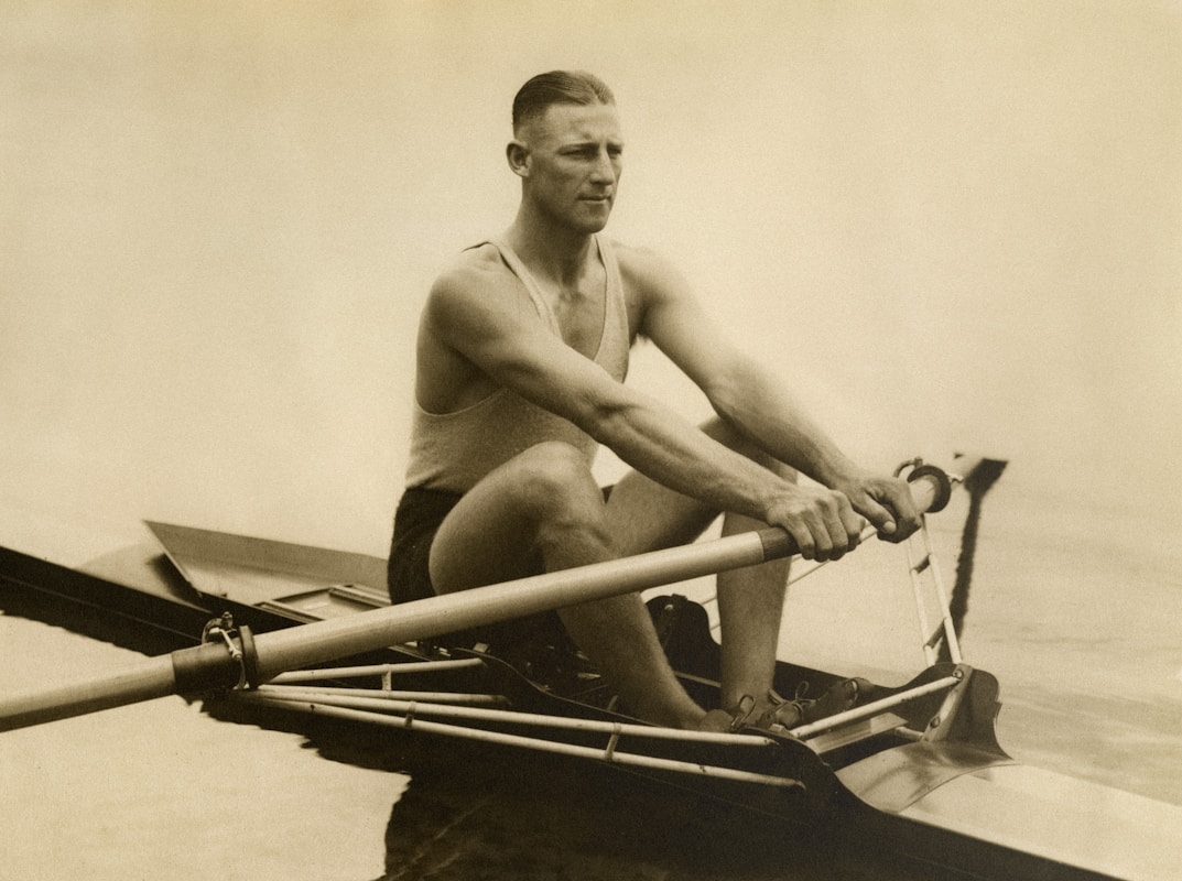 a man rowing a boat on a body of water storia della canoa a Milano
