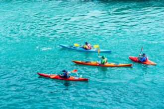 2 person riding on red kayak on body of water during daytime corsi di canoa a Milano