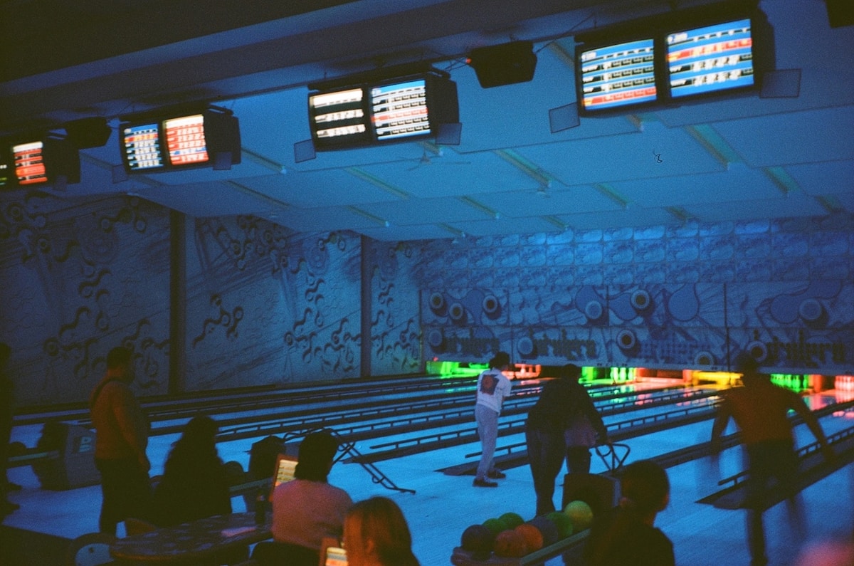 a group of people standing around a bowling alley offerte gruppi bowling Milano