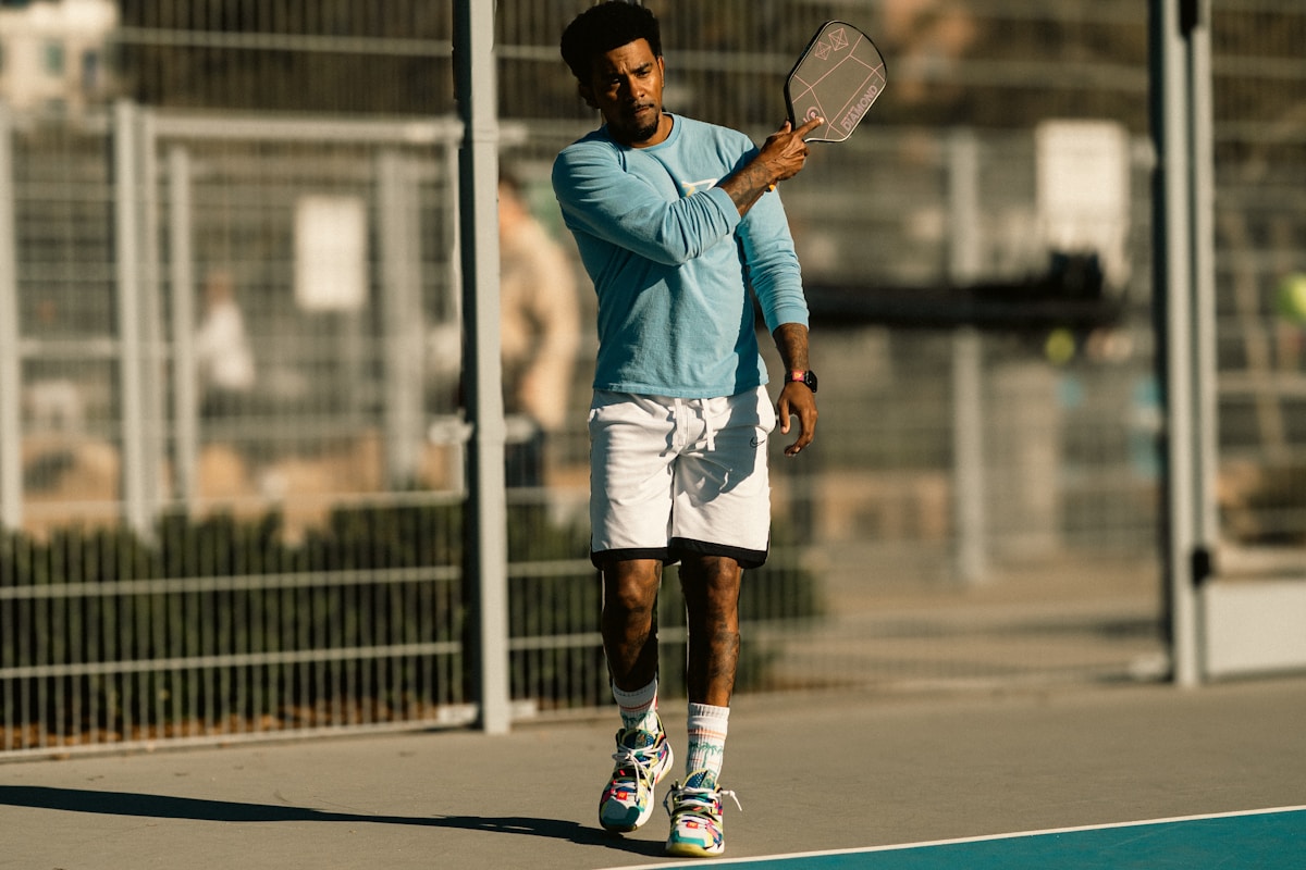 A man holding a tennis racquet on top of a tennis court