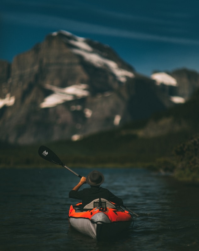 man riding on inflatable kayak beside mountain canoa agonistica a Milano